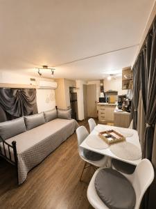 a living room with a couch and a table and chairs at Glykofilousa Tiny Ηouse in Petra +29 photos