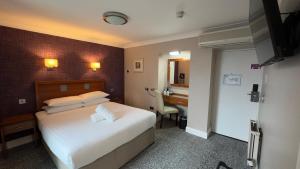 a hotel room with a bed and a desk at Imperial Hotel Galway in Galway +1 photo