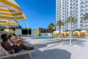 a group of people sitting on chairs next to a swimming pool at Palette Las Vegas in Las Vegas