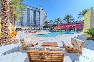 a resort with a pool and palm trees and a building at Palette Las Vegas in Las Vegas