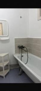 a bath tub in a bathroom with a stool at Квартира у озера in Priozersk