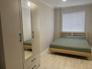 a small bedroom with a bed and a mirror at Квартира у озера in Priozersk