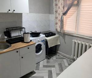 a kitchen with a stove and a washing machine at Квартира у озера in Priozersk