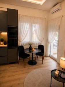 a living room with a table and chairs and a kitchen at VukAs in Palić