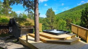 a hot tub on a deck with a tree at ONGA Boutique Lodge in Alta