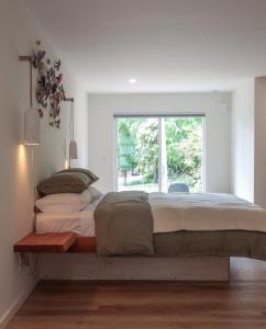 a large bed in a bedroom with a window at The Four Cedars in Ucluelet