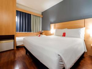 a large white bed in a hotel room at ibis Joinville in Joinville +79 photos