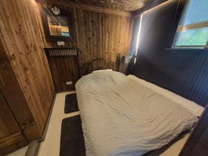 a small bedroom with a bed in a room at Froglets island cabin in Bexley