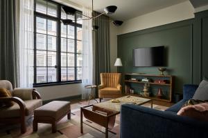 a living room with a couch and a tv at Cincinnati's Fidelity Hotel in Cincinnati