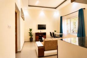 a living room with a couch and a tv at Aparthotel Madeleine in Antananarivo
