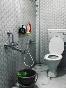 a bathroom with a toilet and a bucket at Oak & olive stays in Tezpur