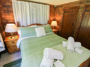 a bedroom with a green bed with towels on it at Severn Bank Lodge in Shrawley