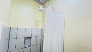 a bathroom with a shower with a white shower curtain at Hotel Costa del Sol in Puerto Limón +27 photos