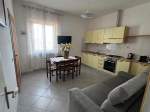 a kitchen and a living room with a couch and a table at Appartamento Marisa2 a soli 200mt dal mare e vista mare in Fetovaia