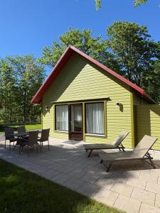 a yellow house with chairs and a patio at Nurmeveski Holiday House in Nurme