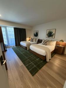 a bedroom with two beds and a green rug at Main & SKY Park City Utah in Park City