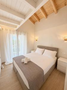 a bedroom with a bed and a large window at Olea Verde Loft Apartment in Lefkimmi