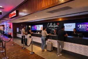 a group of people standing at a counter in a restaurant at Collection O Las Vegas in Las Vegas +26 photos
