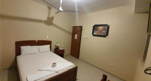 a bedroom with a bed and a clock on the wall at Hotel Roman in Pucallpa +3 photos