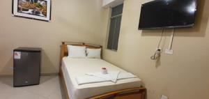a small bedroom with a small bed with a flat screen tv at Hotel Roman in Pucallpa
