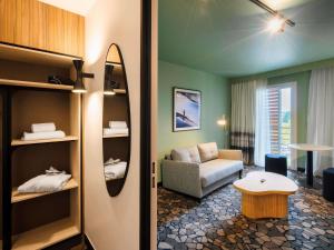 a living room with a couch and a table in a room at Mercure Libourne Saint Emilion in Libourne +60 photos