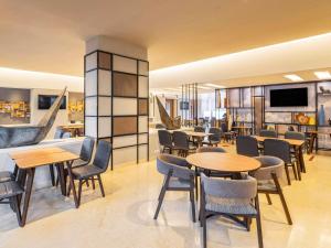 a restaurant with tables and chairs and a couch at ibis Mumbai Airport - An Accor Brand in Mumbai