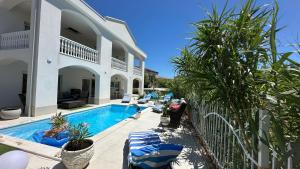 a villa with a swimming pool next to a house at Willa Casa Blanca in Pag