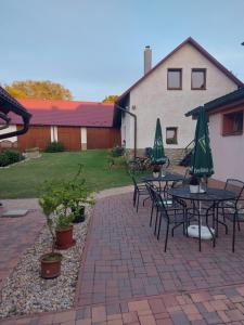 a patio with tables and chairs with green umbrellas at Hostinec u Janatů s ubytováním in Čestín