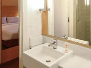 a bathroom with a sink and a mirror and a bed at ibis Buenos Aires Obelisco in Buenos Aires +36 photos