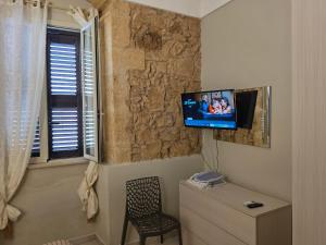 a room with a tv on the corner of a wall at Pasithea House in Marzamemi