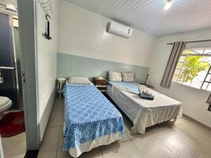 a bedroom with two beds and a toilet at Pousada e Hotel Italian Garden House in Campo Grande +149 photos