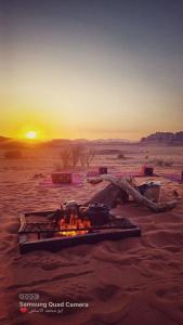 a fire in the desert with the sunset in the background at مخيم سياحي in Disah