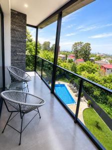 a balcony with two chairs and a swimming pool at phranta in Gonio