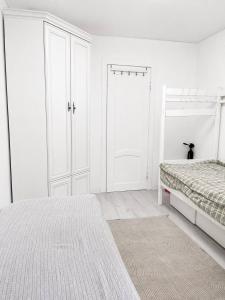 a white bedroom with a bed and a closet at Дом in Almaty