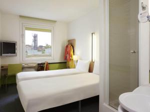 a hotel room with two beds and a window at ibis budget Katowice Centrum in Katowice +49 photos