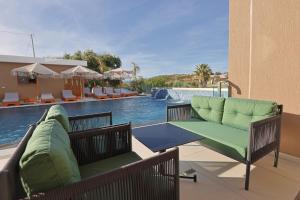a patio with two chairs and a swimming pool at Hotel Landi in Ksamil