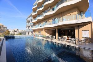 a hotel with a swimming pool in front of a building at Hotel Landi in Ksamil