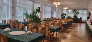 a dining room with green tables and chairs at Uśmiech Morza in Międzyzdroje