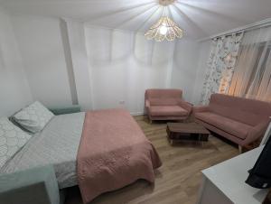 a bedroom with a bed and a couch and a chandelier at Mosquera House in Arzúa