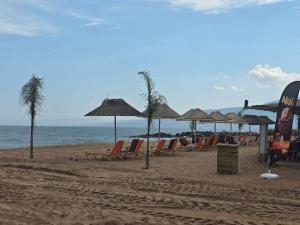 a beach with chairs and umbrellas and the ocean at Nature & Sea Paradise in Analipsi in Análipsis
