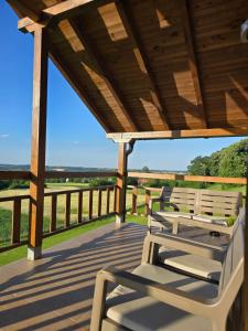 a wooden porch with two chairs on a deck at LIPA houses & spa in Sopot +42 photos