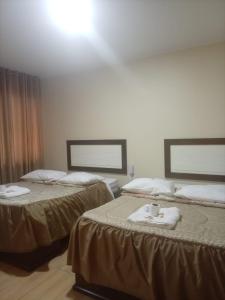 a hotel room with two beds with towels on them at Perú Andina Tours & Hostel Amparo in Huaraz