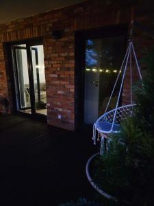 a swing in front of a house at night at Apartament Przystań in Łeba