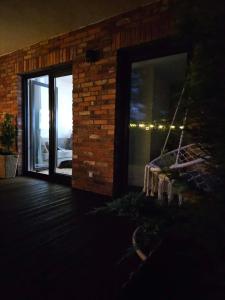 a room with a glass door and a brick wall at Apartament Przystań in Łeba