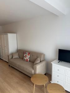 a living room with a couch and a tv at White Villa in Darlowko