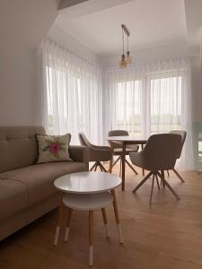 a living room with a couch and a table at White Villa in Darlowko