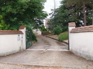 an empty driveway with a gate in a yard at Belle maison proche du futuroscope in Thuré