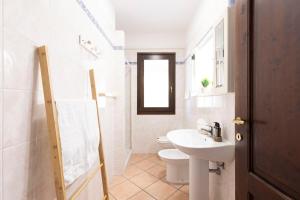 a white bathroom with a sink and a toilet at Villa Luna in Simius +29 photos