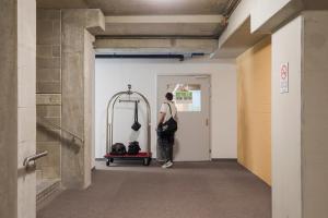 a man walking into a hallway with a bag at Ostello Sport Center in Monte Ceneri
