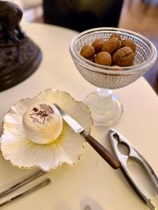 a table with a bowl of peanuts and a plate with a knife at Maison VCB Ciney - Hôtel Particulier de 1820, Cœur de Ville, Parc & Parking Privé in Ciney